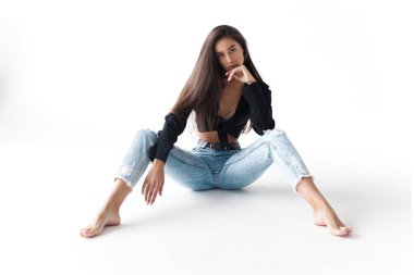 Siyah gömlekli ve beyaz arka planda mavi muz kotlu havalı genç kız. Modaya uygun modern tarz.