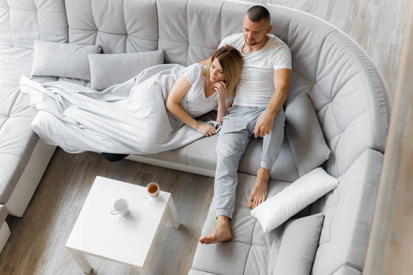 Genç çift evde koltukta dinleniyor. Aile gevşeme yaşam tarzı