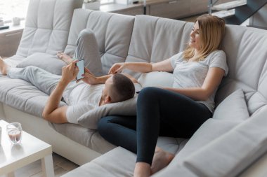 Genç çift evde koltukta dinleniyor. Aile gevşeme yaşam tarzı