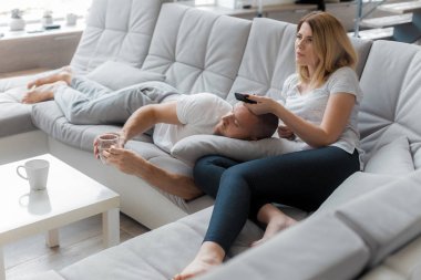 Genç çift evde koltukta dinleniyor. Aile gevşeme yaşam tarzı