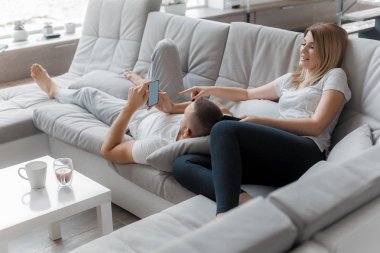 Genç çift evde koltukta dinleniyor. Aile gevşeme yaşam tarzı