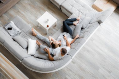 Genç çift evde koltukta dinleniyor. Aile gevşeme yaşam tarzı