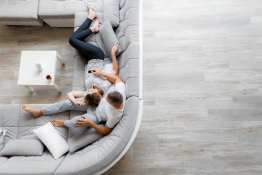 Genç çift evde koltukta dinleniyor. Aile gevşeme yaşam tarzı