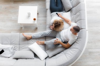 Genç çift evde koltukta dinleniyor. Aile gevşeme yaşam tarzı