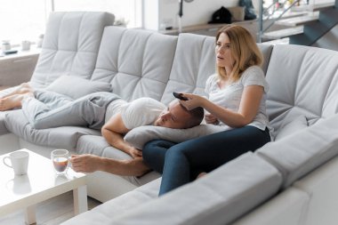 Genç çift evde koltukta dinleniyor. Aile gevşeme yaşam tarzı