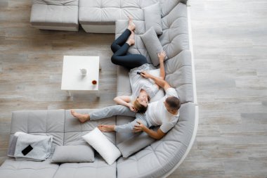 Genç çift evde koltukta dinleniyor. Aile gevşeme yaşam tarzı