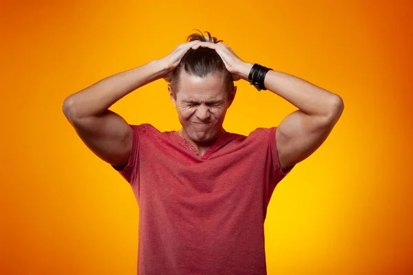 Adult Man Holds His Fingers His Hair Orange Background Stress — Stock Photo, Image