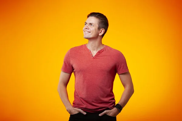 Adult cheerful man smiling on an orange background. Positive and success concept