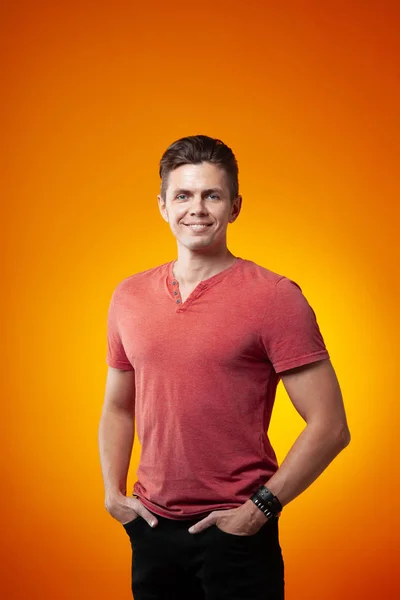 Adult cheerful man smiling on an orange background. Positive and success concept