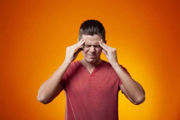 Adult Man Holding Fingers Temple Orange Background Stress Headache Concept — Stock Photo, Image
