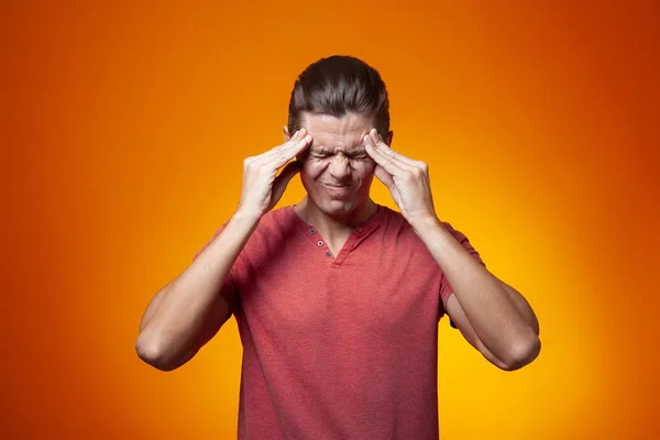 Adult Man Holding Fingers Temple Orange Background Stress Headache Concept — Stock Photo, Image