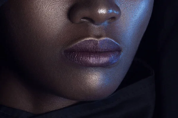 Lips of young beautiful black woman with clean perfect skin. Beauty, cosmetics and makeup