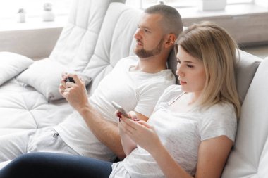 Adam oyun Tv konsol. Telefon kullanan kadın. Aile hafta sonu dinlenmek ev kanepe