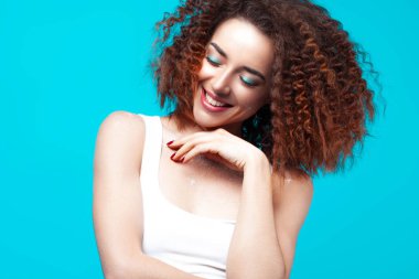 Mavi arka plan üzerinde güzel gülümseyen genç kadın. Tatil ve duygular kavramı