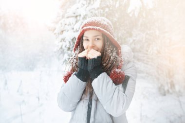 Genç kız ormanda nefes tarafından elleri ısıtır. Pozitif ve yaşam tarzı kavramı
