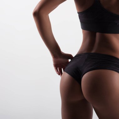 Güzel seksi kadının tabaklanmış deri üzerinde beyaz arka plan ile atletik mükemmel vücut. Spor ve sağlıklı yaşam tarzı. Anonim portre