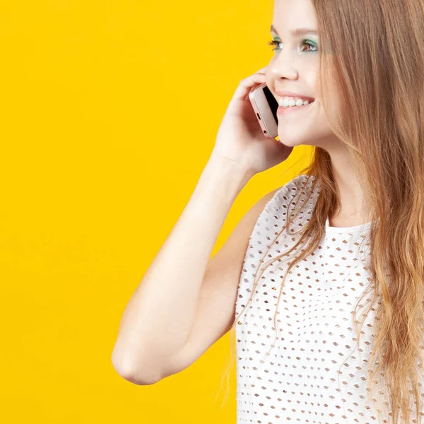 Cheerful young girl talking on phone and smiling. Emotions, communication and technology