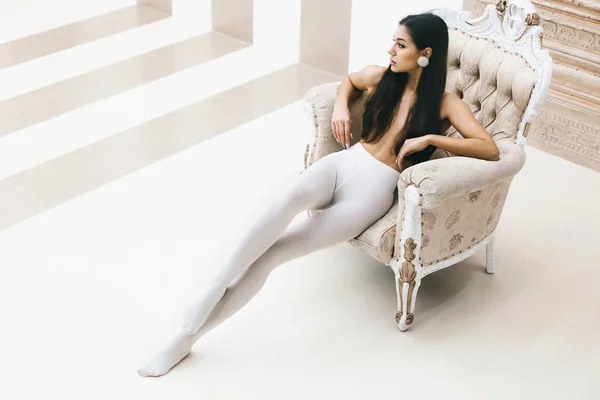 Beyaz külotlu çorap genç zarif kız lüks sandalyeye oturur. Trendy retro vintage tarzı. Yüksek moda