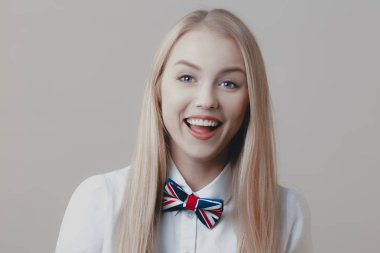 Tatlı bir oynak genç sarışın papyon ile dalga geçiyor. Duygu ve yaşam tarzı