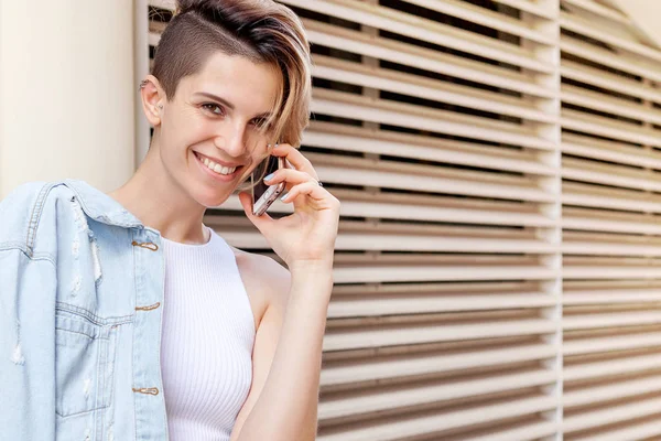 Young smiling woman speaks by phone. Lifestyle portrait