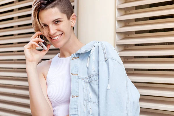 Young smiling woman speaks by phone. Lifestyle portrait