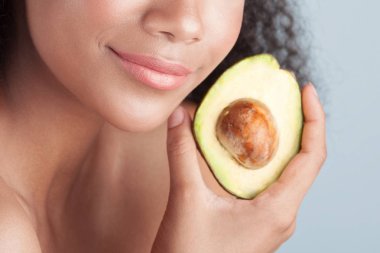 Avokado yakın çekim ile temiz mükemmel cilt ile genç zenci kız. Güzellik Portresi