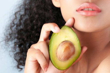 Avokado yakın çekim ile temiz mükemmel cilt ile genç zenci kız. Güzellik Portresi