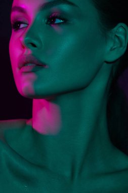 Genç güzel kız mor ve yeşil neon aydınlatma ile. Duygusal güzellik yakın çekim portre
