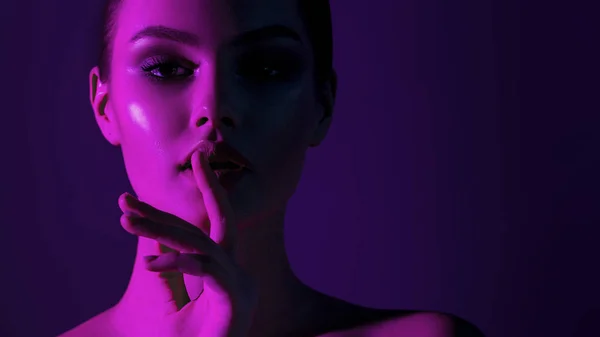 Tsss... Genç güzel kız pembe neon aydınlatma ile. Duygusal güzellik yakın çekim portre