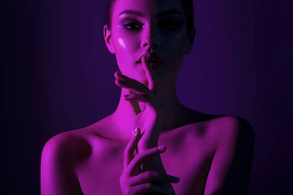 Tsss... Genç güzel kız pembe neon aydınlatma ile. Duygusal güzellik yakın çekim portre
