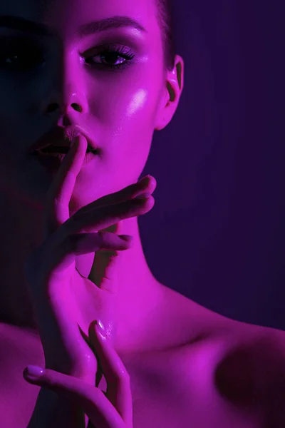 Tsss... Genç güzel kız pembe neon aydınlatma ile. Duygusal güzellik yakın çekim portre