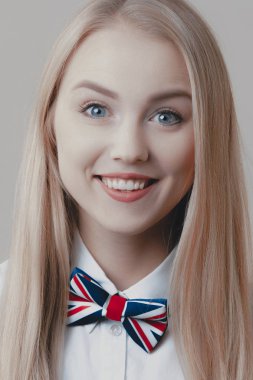 Tatlı bir oynak genç sarışın papyon ile gülümsüyor. Duygu ve yaşam tarzı