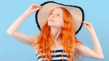 Kızıl saçlı kız eller hasır şapka tutan ve örnek alıyor. Sahilde rahatlatıcı hayalleri. Duygu ve yaşam tarzı