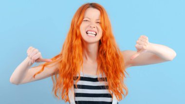 Red-haired girl frowns, grins and shows thumb down. Negative and Condemnation clipart