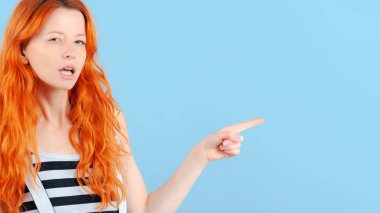 Kızıl saçlı kız frowns ve parmağıyla işaret eder. Promosyon için şablon. Duygu ve yaşam tarzı