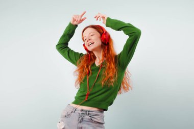 Kızıl saçlı kız kulaklıklar müzik ve dans. Pozitif, yaşam tarzı ve teknoloji
