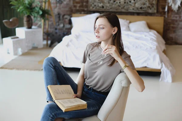 Jong lief meisje met bril zit en leest boek — Stockfoto