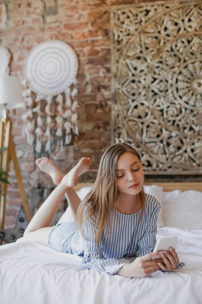 Jeune fille douce couchée sur le lit avec téléphone — Photo