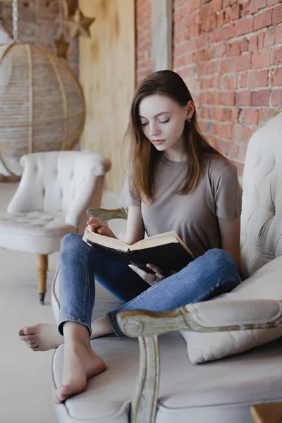 Jeune fille douce avec des lunettes s'assoit et lit livre — Photo