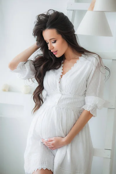 Mladá krásná těhotná žena v bílých šatech — Stock fotografie
