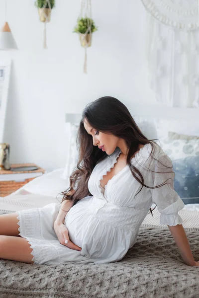 Mladá krásná těhotná žena v bílých šatech — Stock fotografie