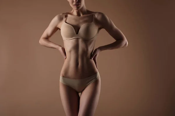 Skinny ung kvinna i underkläder håller händerna på hennes midja — Stockfoto