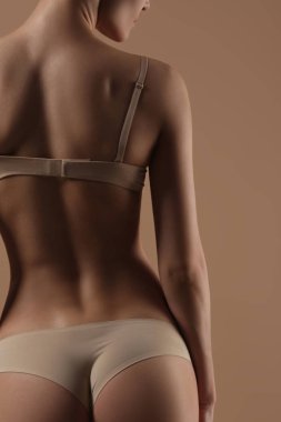 Bej arka planda iç çamaşırı ince genç kadın