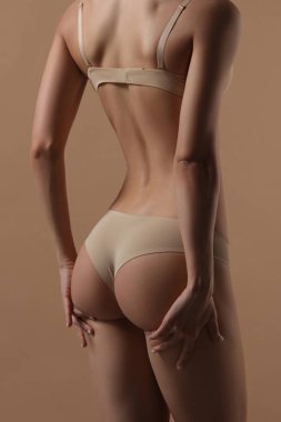 Iç çamaşırı skinny genç kadın eliyle kalçasını kaldırır
