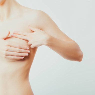 Sllender üstsüz kadın göğüslerini kontrol ediyor. Elle muayene, tümör tespiti, topaklar, neoplazmalar. Test, kanser önleme için kontrol.