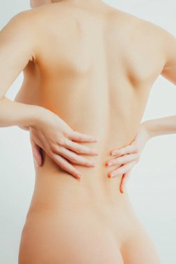 Çıplak ince kadın sırtına dokunuyor. Omurga ağrısı, böbrek iltihabı, osteokondrosis.