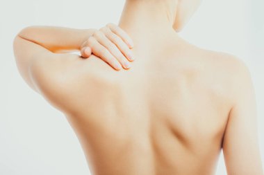 İnce, çıplak bir kadın boynuna ve omuzlarına masaj yapıyor. Omurga ağrısı, osteokondrosis, yorgunluk.