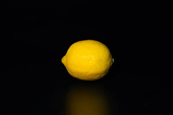 A single lemon on a black background