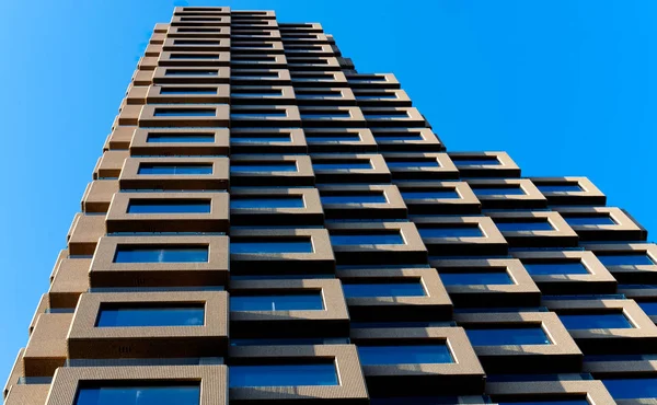 Close up of a building made up of several square boxes. Close up with a vanishing point and hard ligt from the left with shadows