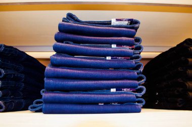 Katlanmış kotlar ahşap rafta duruyor..